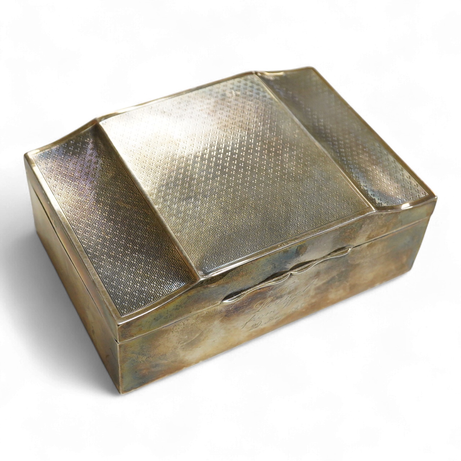 A George V part engine turned silver mounted cigarette box, by Clark & Sewell, with serpentine lid and engraved inscription, Birmingham, 1928, length 12.9cm.